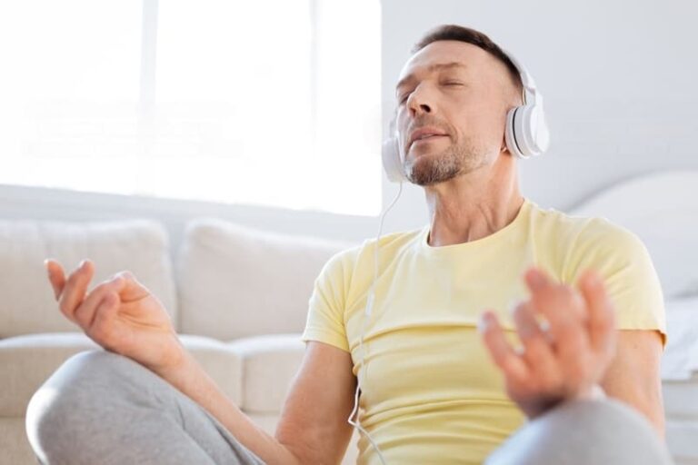 a man wearing a yellow shirt wearing headphones listening to the power of guided meditation