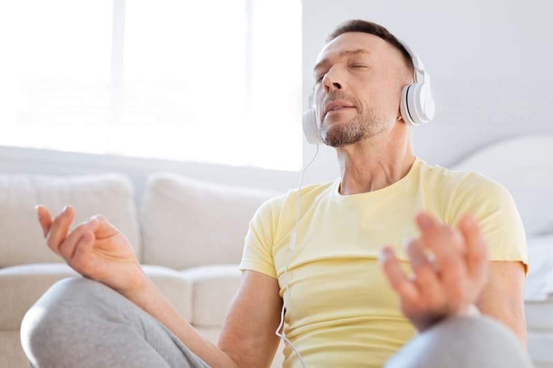 a man wearing a yellow shirt wearing headphones listening to the power of guided meditation