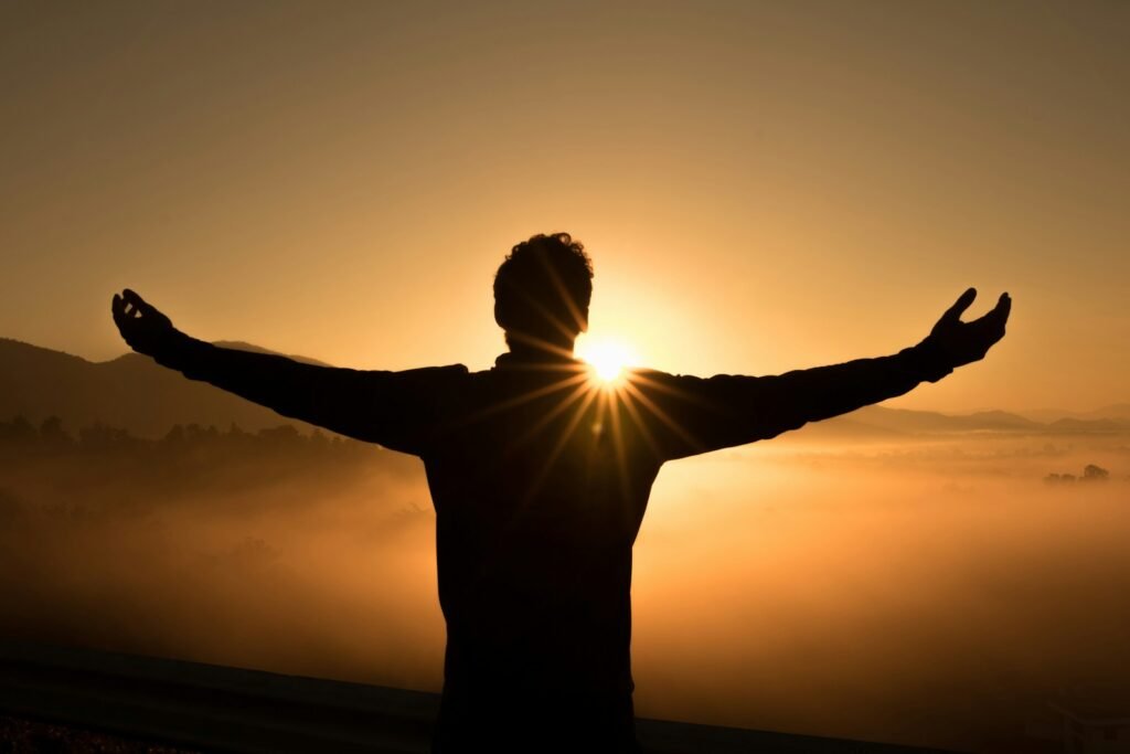 silhouette photo of a man on a cliff during sunset, experiencing stillness, your secret to mental clarity