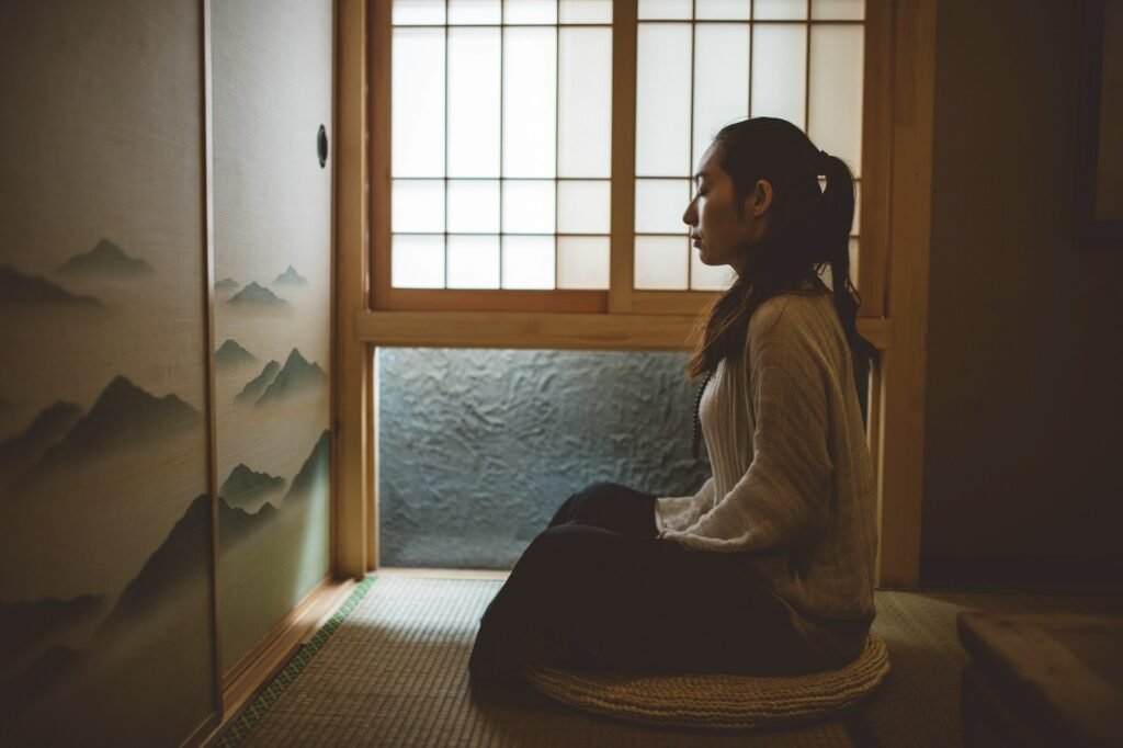 woman sitting on floor near window finding serenity with the deep impact of meditation