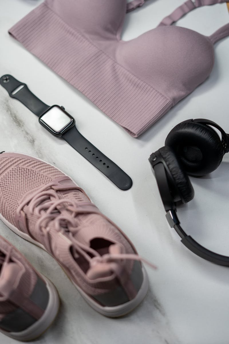 Black meditation app headphones beside rose-colored sneakers