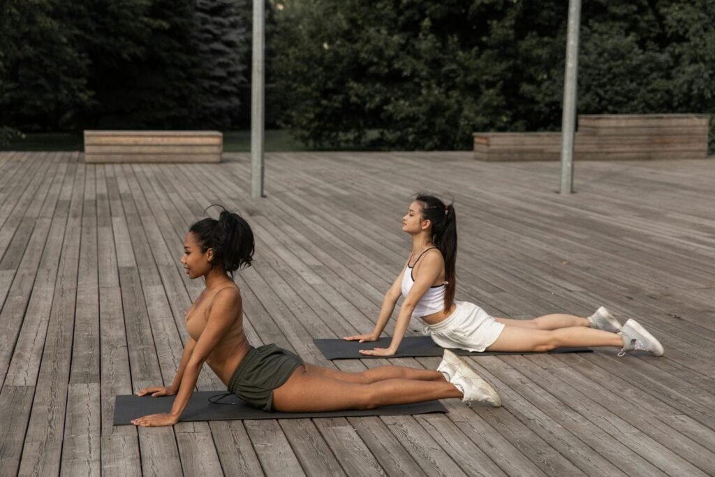 Side view of two girlfriends doing the Cobra pose