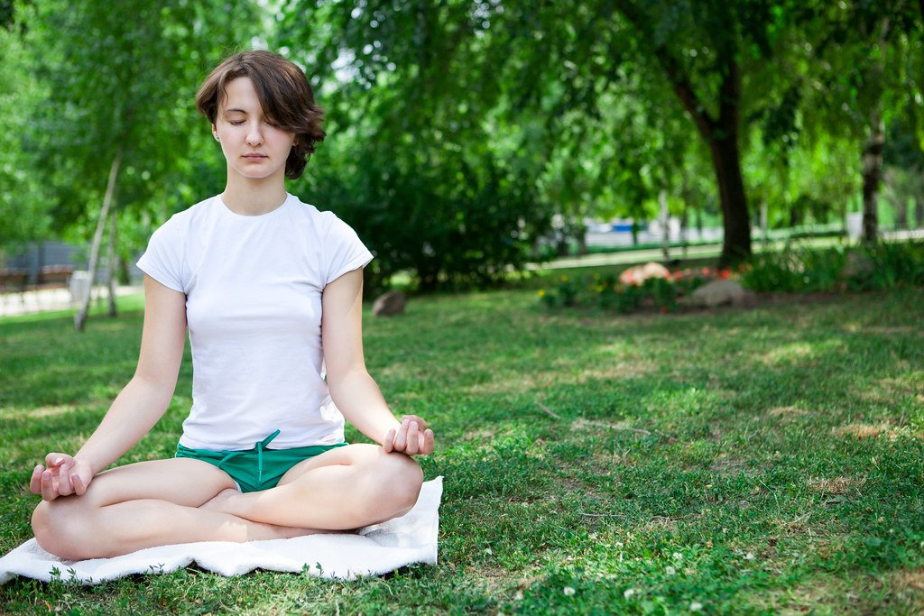 A woman meditating in the park