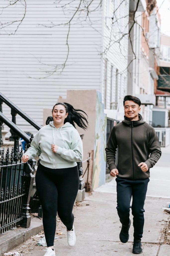 Happy man and woman jogging to lose weight fast on a city street