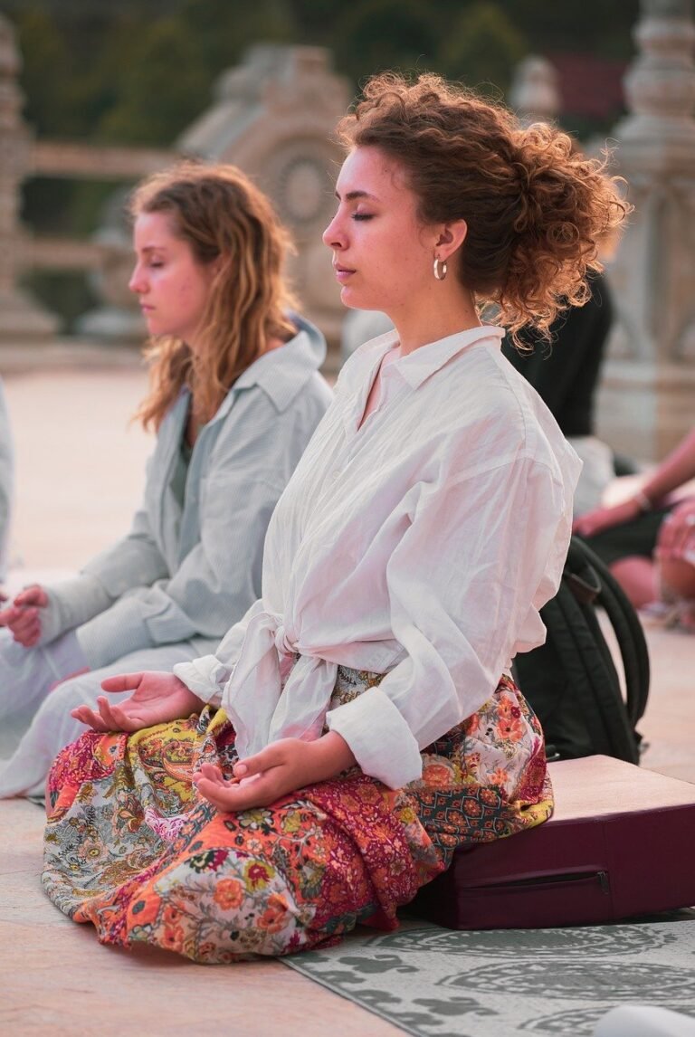 Two women practicing meditation and yoga to discover the awareness and mindfulness difference