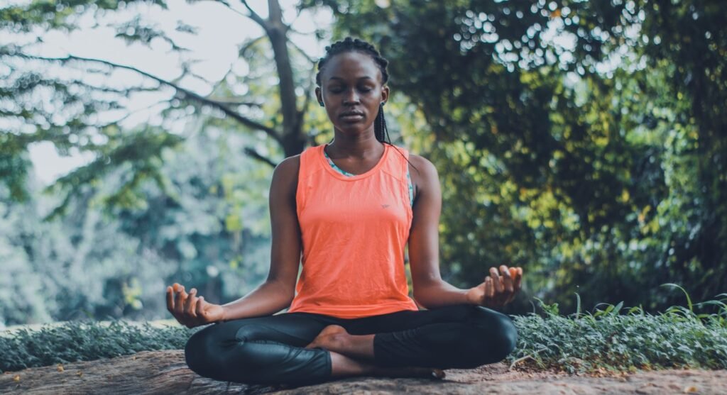 A woman practicing yoga and meditation outdoors