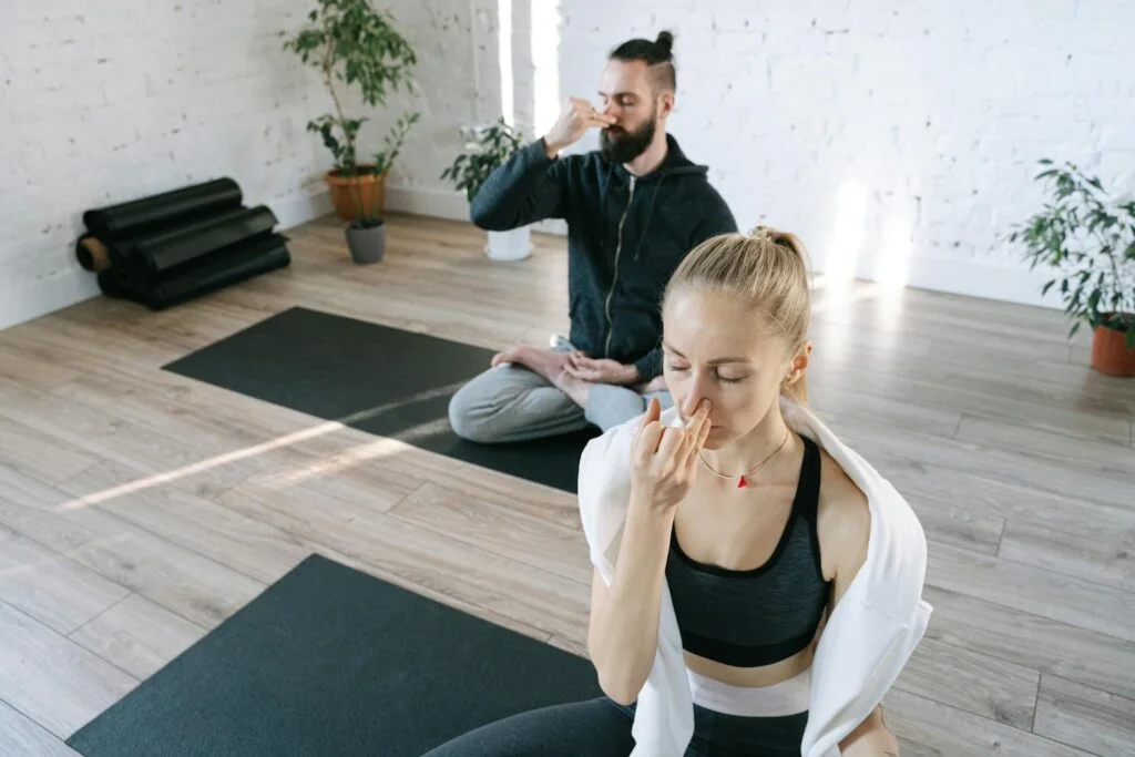 A man and a woman using breathwork breathing exercises in meditation