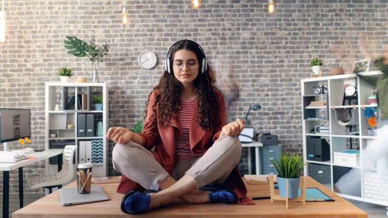 A woman sitting practicing vipassana meditation in a room with headphones