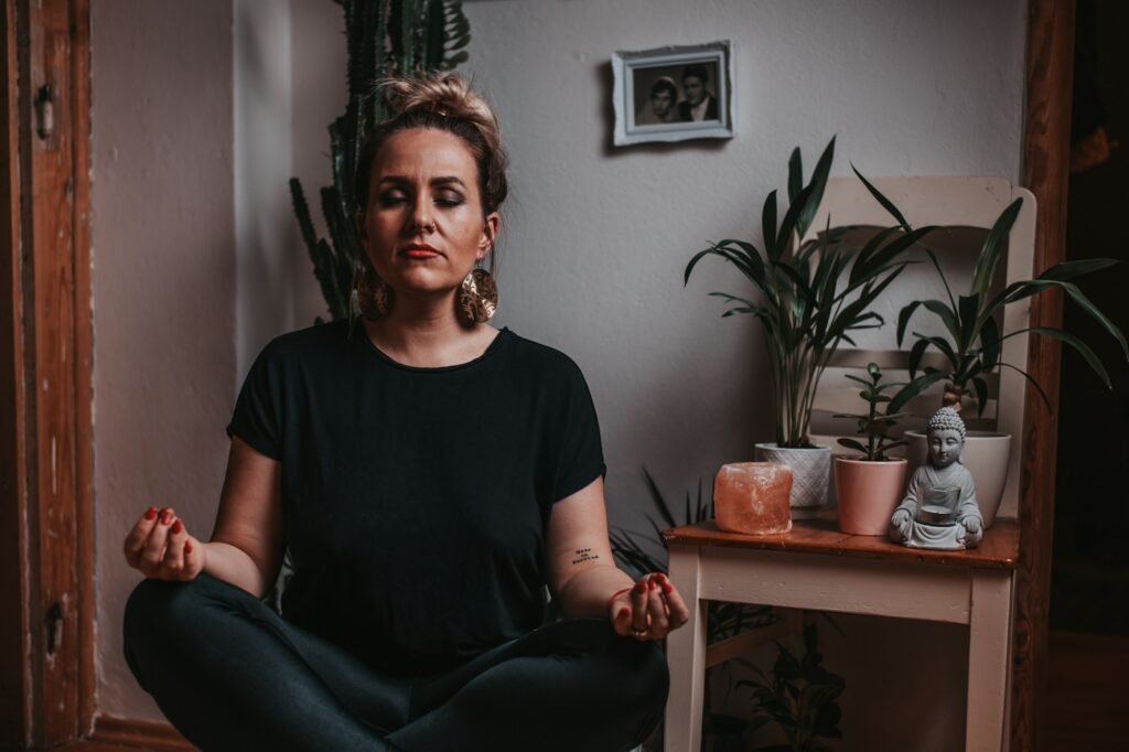 A woman in a black crew neck t-shirt sitting on a black leather armchair