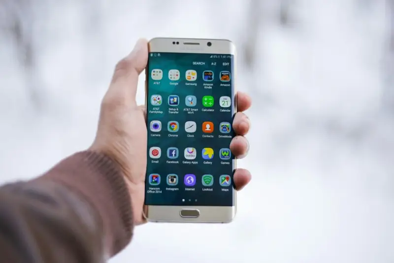 A person holding a silver Android smartphone with sleep meditation apps on it