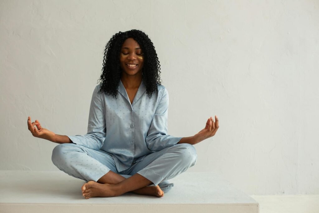 A woman wearing blue sleepwear meditating for inner peace