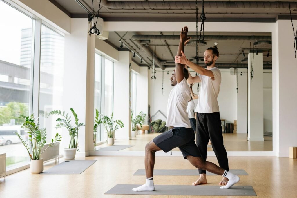 A yoga instructor teaching a student in a yoga class the benefits of yoga