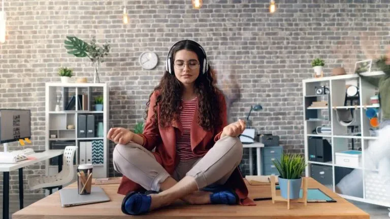 A woman sitting practicing vipassana meditation in a room with headphones